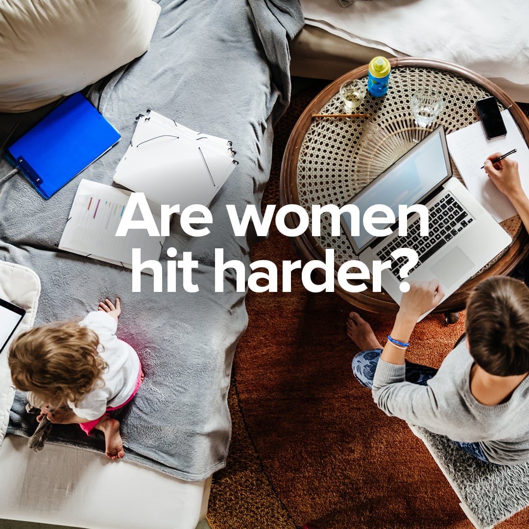 Looking downward on to a woman working at her lap top. next to her space is a toddler on the couch.