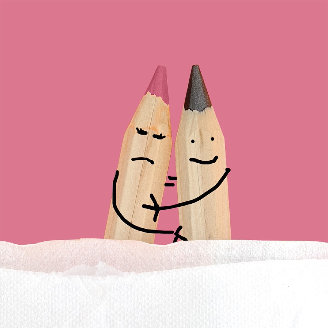 pink background showing the tips of 2 sharp pencils close beside each other. There are faces and arms drawn on each pencil to look like they are in an embrace. one is not happy. 